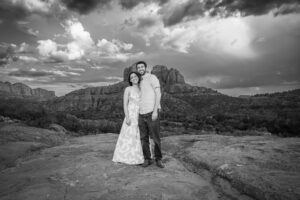 Example Alt Text: Family of three laughing during their sunset anniversary photo session on Secret Slick Rock Trail in Sedona, Arizona