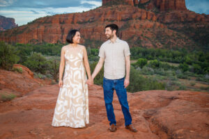Example Alt Text: Family of three laughing during their sunset anniversary photo session on Secret Slick Rock Trail in Sedona, Arizona