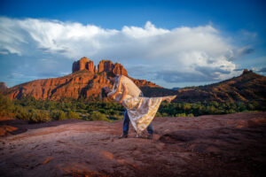 Example Alt Text: Family of three laughing during their sunset anniversary photo session on Secret Slick Rock Trail in Sedona, Arizona